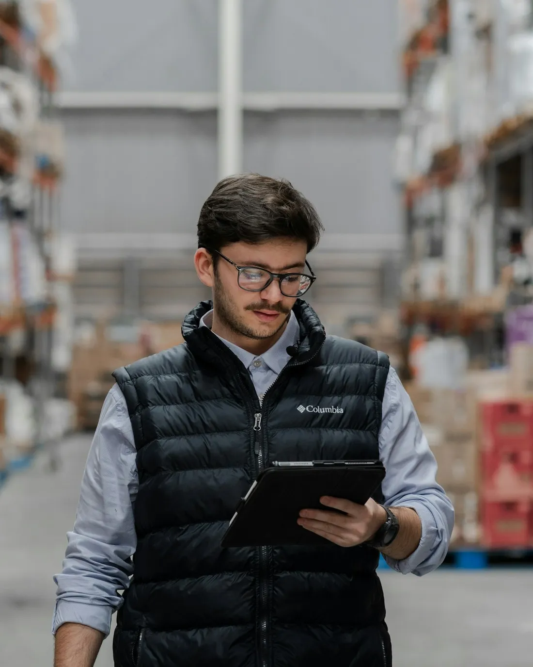 Especialista en logística revisando inventario con una tableta en un almacén