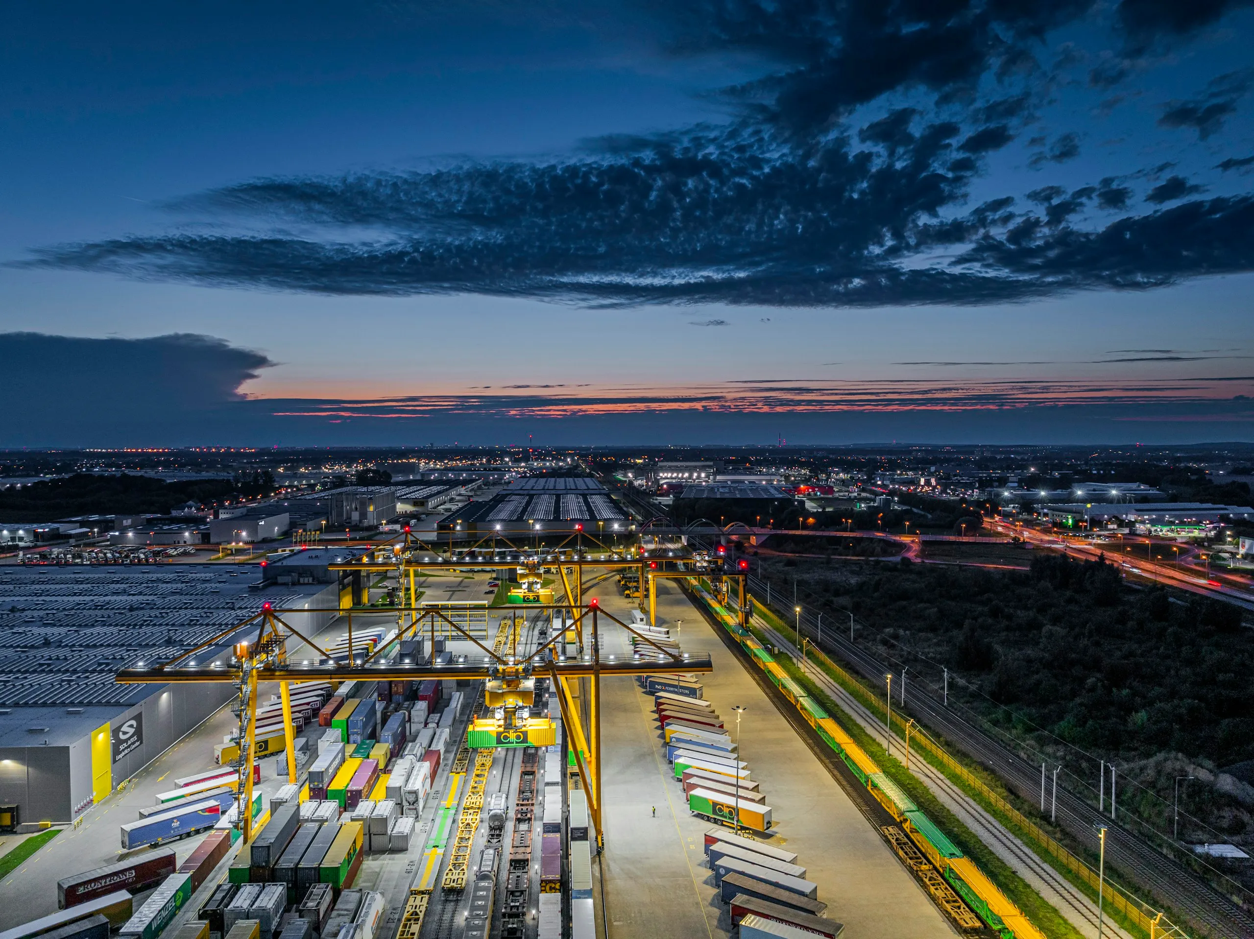 Terminal intermodal de contenedores operando al anochecer